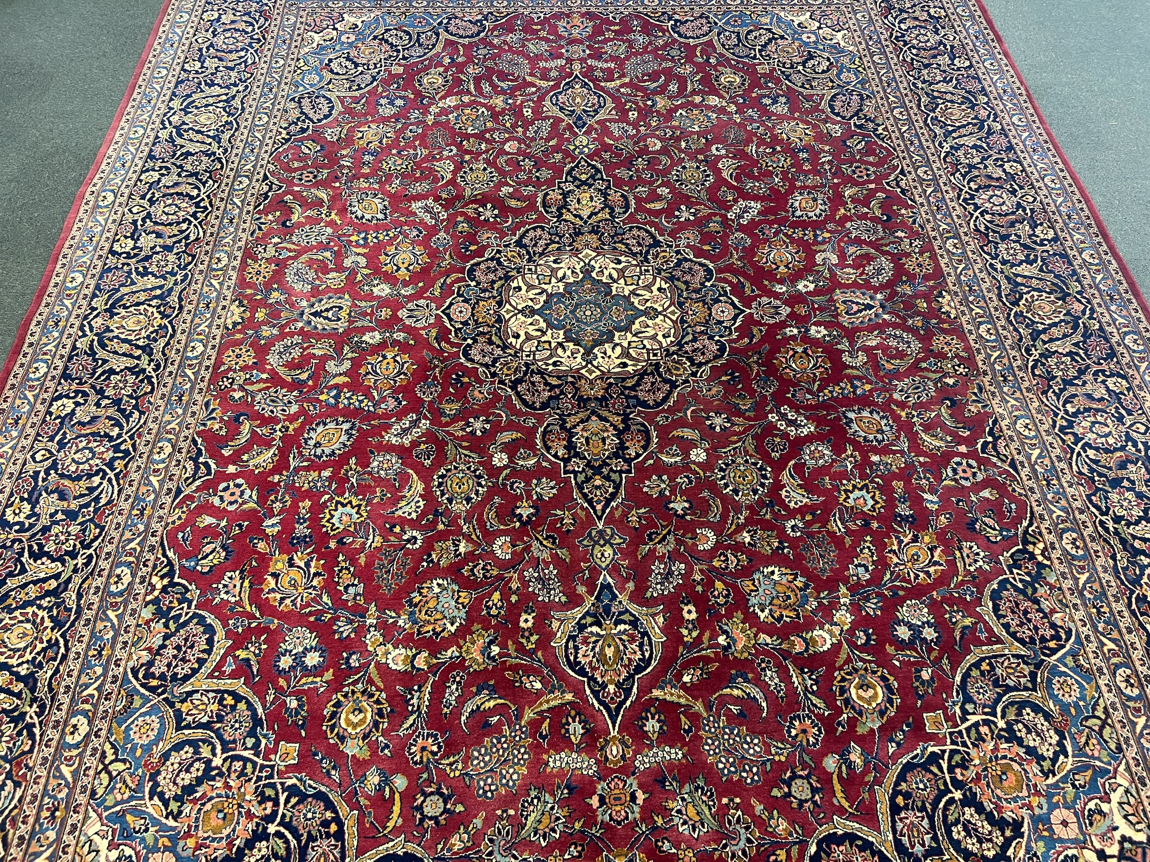 A Kashan burgundy ground carpet